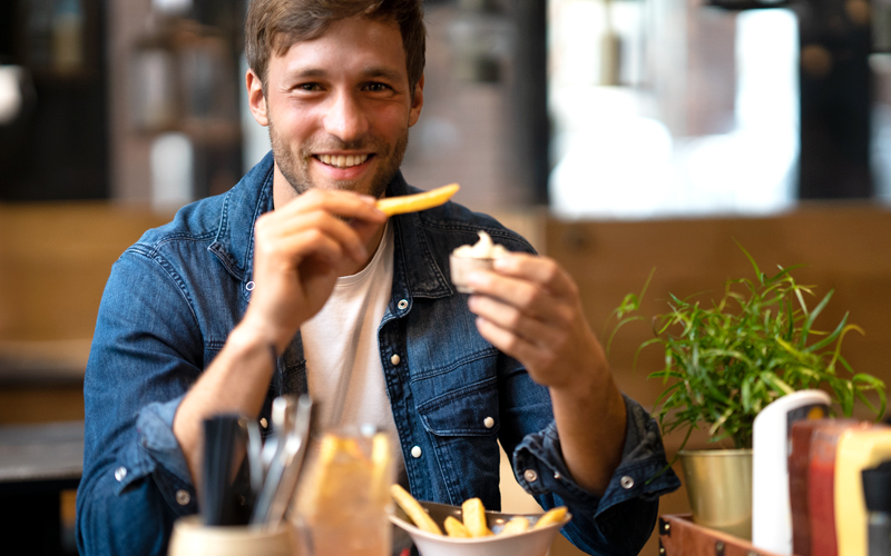Mann isst Pommes bei Peter Pane